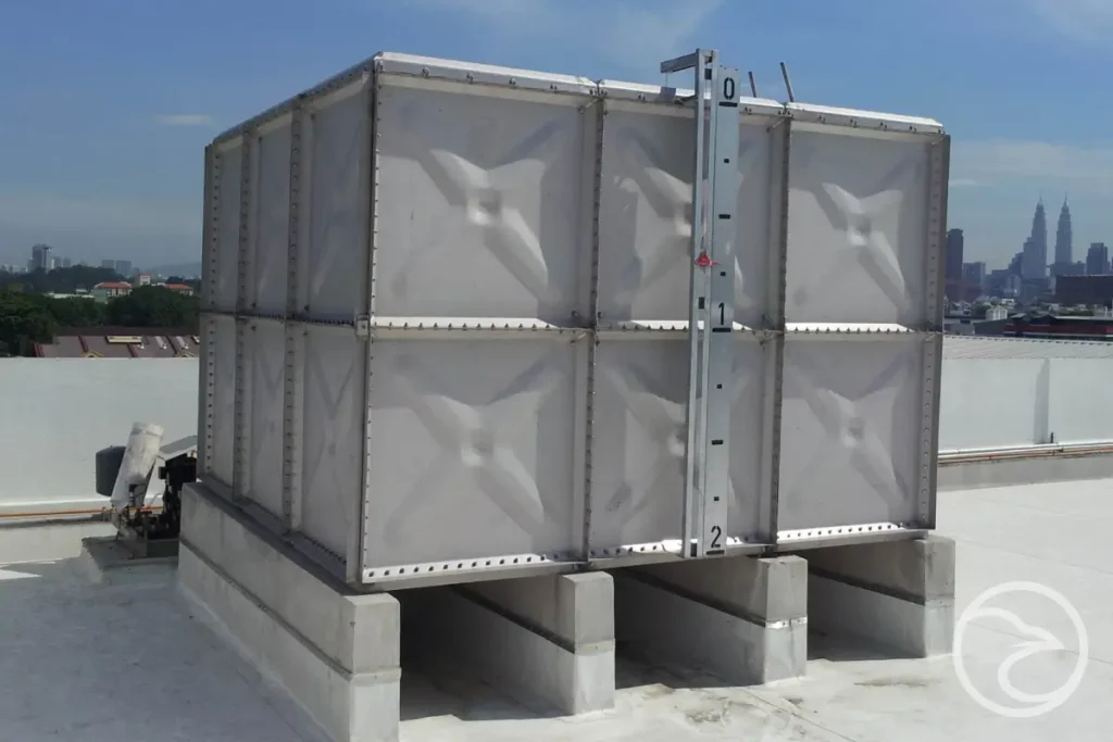 Steel square water tank next to industrial building