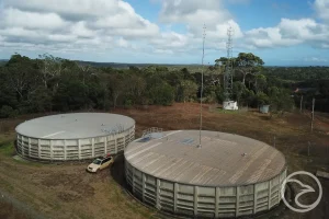 Technician reviewing smart monitoring equipment on an industrial water tank