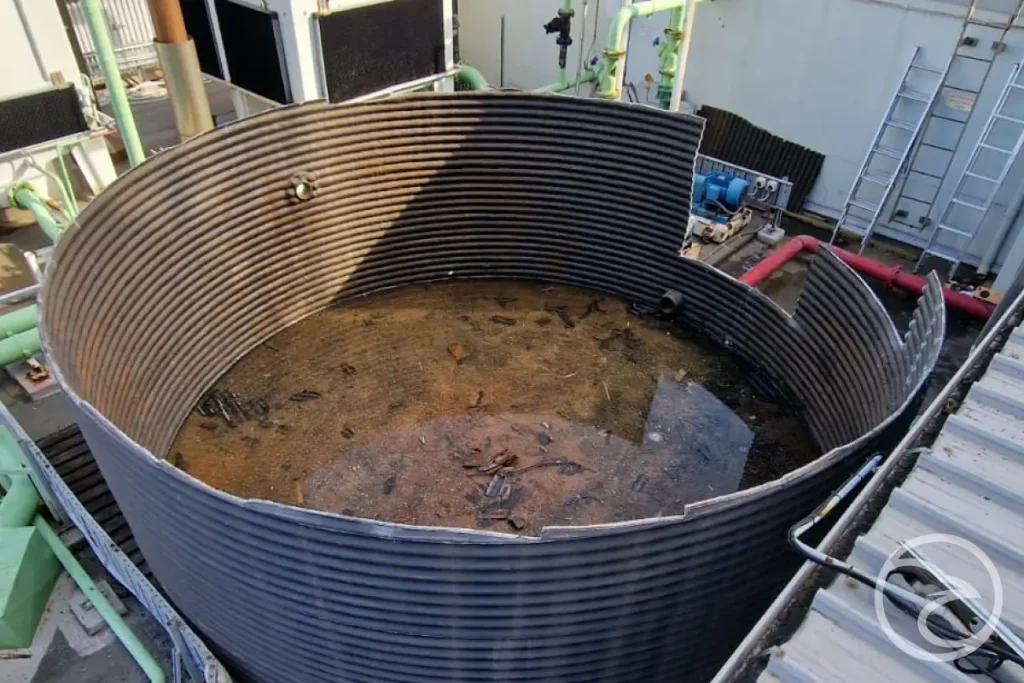 Water storage tank interior showing sediment buildup during maintenance